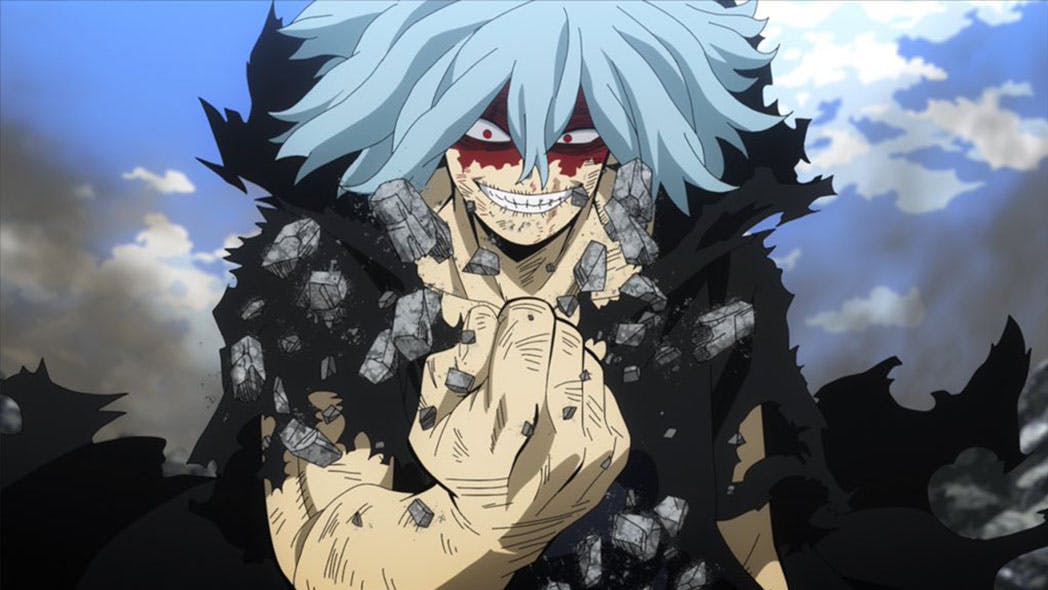 Tomura Shigaraki, an ominous figure with blood-stained eyes and forehead, dons a tattered, half-destroyed black cloak. Utilizing his destructive power, Decay, he unveils the intensity of his formidable abilities, with a chilling display on a stone hand.{caption: Tomura Shigaraki in My Hero Academia (Season 5 Episode 24)}