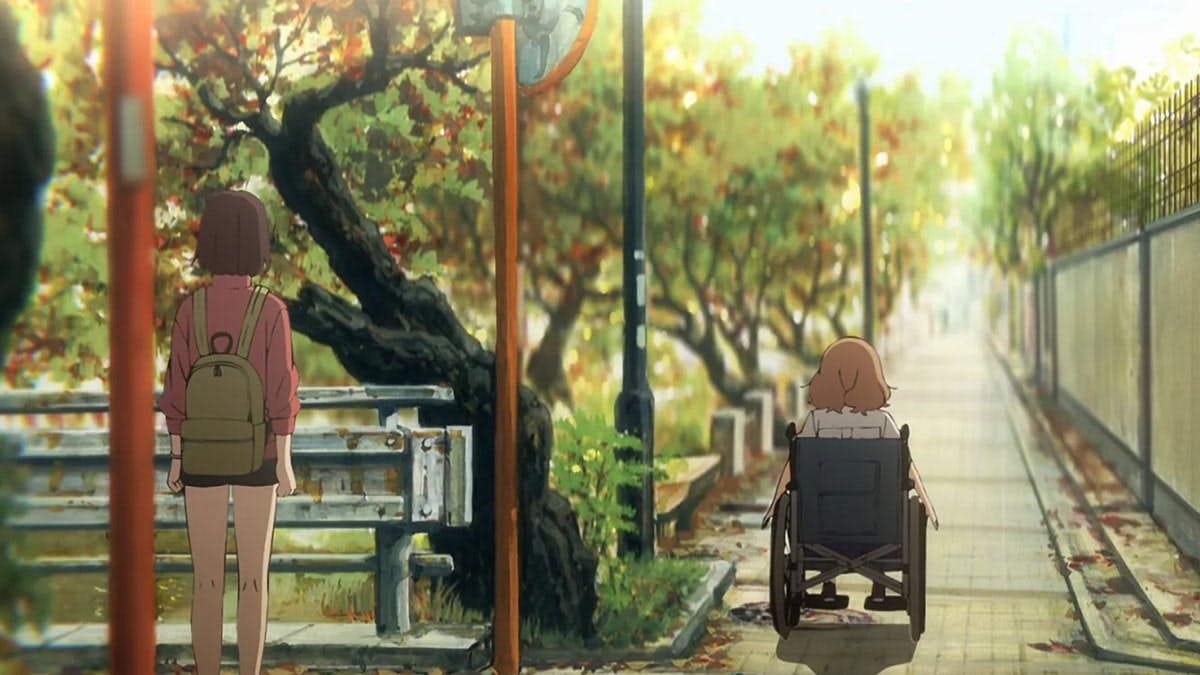 In a scene from the movie 'Josee, the Tiger and the Fish,' the protagonist, seated in a wheelchair, moves away from a girl, creating a bittersweet atmosphere as their paths diverge, their expressions capturing a mix of longing, acceptance, and the complexities of personal growth and relationships.