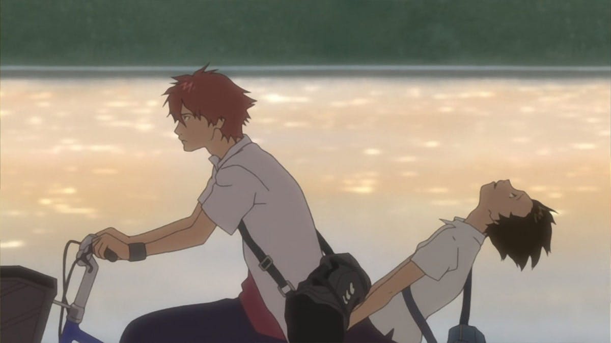 In a scene from the movie 'The Girl Who Leapt Through Time,' the two protagonists ride a bicycle together, with the person in the back leaning back in annoyance, while a serene river flows peacefully behind them, capturing a moment of playful disagreement and the backdrop of tranquil nature that contrasts their dynamic journey through time.